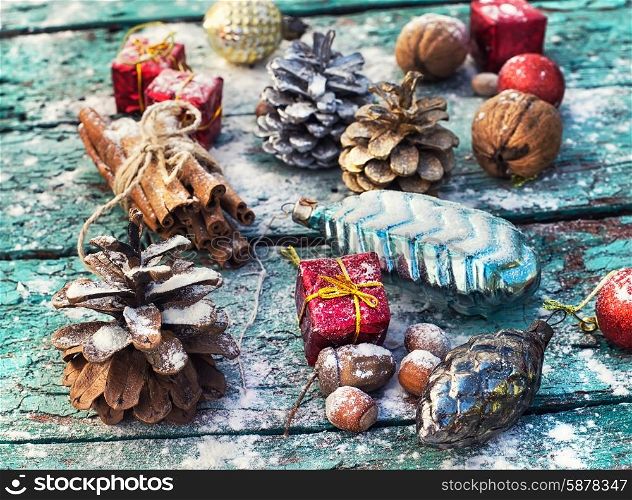 Christmas composition.. Gifts and decorations for Christmas on wooden background strewn with pine cones and spices