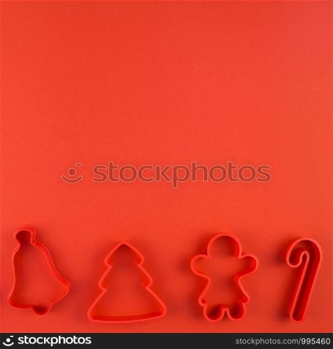 Christmas composition. New Year or Christmas flat lay top view Xmas holiday 2020 cookies cutters set on red paper background with copyspace. Template mockup greeting card text design