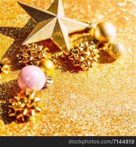 Christmas composition. New Year or Christmas pattern flat lay top view Xmas holiday celebration sparkling golden decoration on golden background with copy space. Template of greeting card