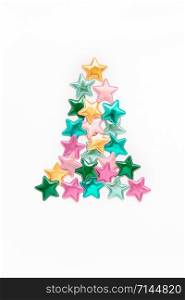 Christmas composition. New Year pattern flat lay top view Xmas holiday celebration decorative color stars Christmas tree concept on white background with copy space. Template of greeting card