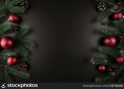 christmas composition of green fir tree branches with red baubles
