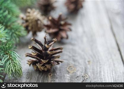 Christmas composition: pine cones and spruce branches on the background of old unpainted wooden boards. Christmas wallpaper