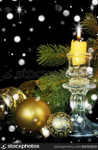 Christmas composition with a burning candle, fir branches and golden Christmas balls on a black background; with copy-space