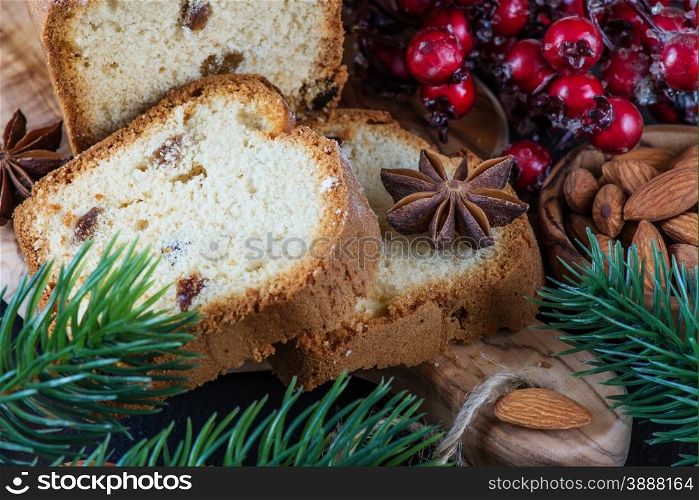 Christmas composition with a sliced cake and spruce branches on a dark background
