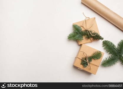 Christmas composition with green fir branches and kraft paper gift boxes on white background, Top view with copyspace.. Christmas composition with green fir branches and kraft paper gift boxes on white background, Top view with copyspace