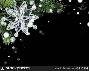 Christmas composition with transparent snowflake on green fir branch isolated a black background, with copy-space