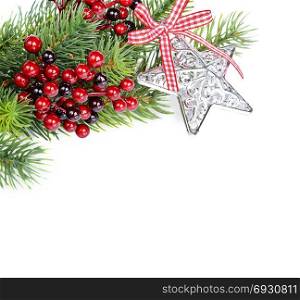 Christmas compositionon with green fir branches, red holly barries, silver star and white-red checkered bow isolated on a white background