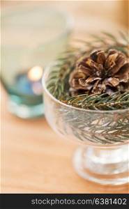 christmas concept - close up of decoration of fir twig with pinecone in dessert bowl. close up of christmas decoration of fir and cone