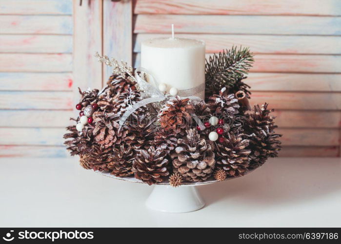 Christmas cones candlestick. Christmas candlestick on the table, decoration with cones