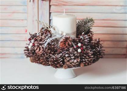 Christmas cones candlestick. Christmas candlestick on the table, decoration with cones