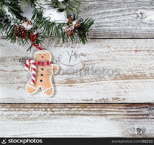Christmas cookie ornament hanging in rough fir tree branch on rustic white wooden background