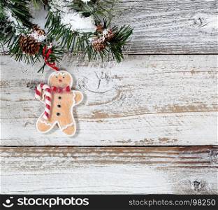 Christmas cookie ornament hanging in rough fir tree branch on rustic white wooden background