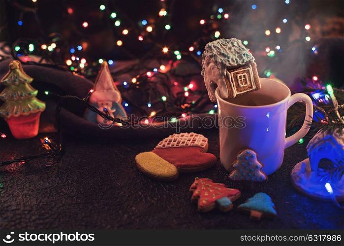 Christmas cookies and cup of tea on daark color bokeh lights background. Christmas cookies and cup of tea