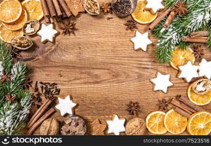 Christmas cookies and spices. Holidays food ingredients with christmas tree decoration on rustic wooden background