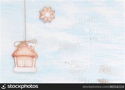 Christmas cookies as a house and snowflake on a light wooden background