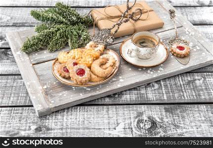 Christmas cookies with coffee and decorations on rustic wooden background