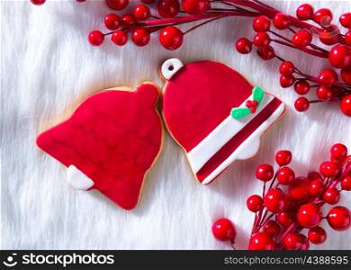 Christmas cookies Xmas red bell shape on white fur background
