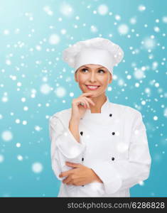 christmas, cooking, holidays and people concept - smiling female chef, cook or baker dreaming over blue snowy background background