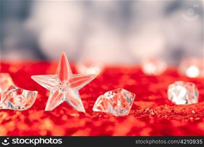 Christmas crystal star on ice cubes with blue lights bokeh background