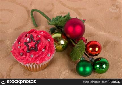 Christmas cupcake with tree ornament on gold background