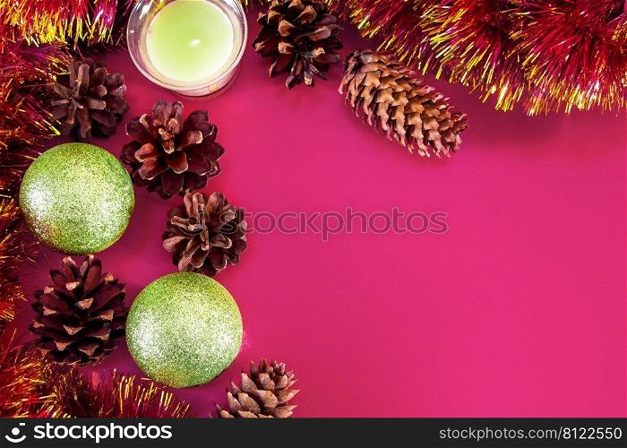 Christmas decor - cones, Christmas balls and branches on a pink background. Aroma candle for a pleasant holiday. Place for your text.. Christmas decor - cones, Christmas balls and branches on a pink background. Aroma candle for a pleasant holiday.