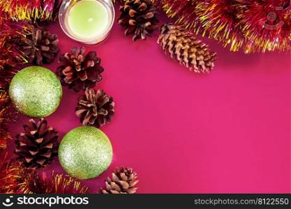 Christmas decor - cones, Christmas balls and branches on a pink background. Aroma candle for a pleasant holiday. Place for your text.. Christmas decor - cones, Christmas balls and branches on a pink background. Aroma candle for a pleasant holiday.