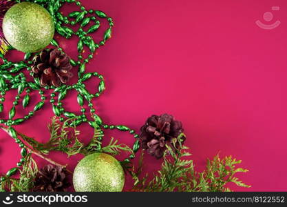 Christmas decor - cones, Christmas balls and branches on a pink background. Aroma candle for a pleasant holiday. Place for your text.. Christmas decor - cones, Christmas balls and branches on a pink background. Aroma candle for a pleasant holiday.