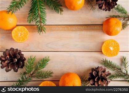 Christmas decor. Fir branches, cones and tangerines on a wooden background.. Christmas decor. Fir branches, cones and tangerines on wooden background.