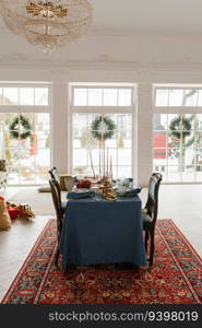 Christmas decor in the living room with large windows, dining table with Christmas wreaths