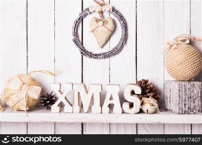 Christmas decor on the shelf - wooden letters XMAS over wooden wall. Christmas decor on the shelf