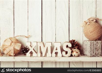 Christmas decor on the shelf - wooden letters XMAS over wooden wall. Christmas decor on the shelf