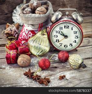 Christmas decoration. An alarm clock and bag of nuts on the background of Christmas decorations