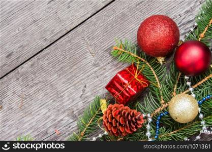 Christmas decoration baubles with branches of fir tree on wooden background