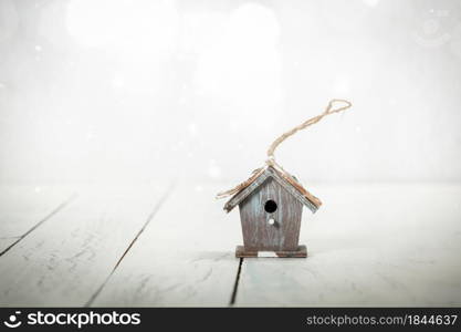 Christmas decoration birdhouse on rustic wooden background. Vintage style toned picture. Miniature birdhouse on rustic wooden background, copy space