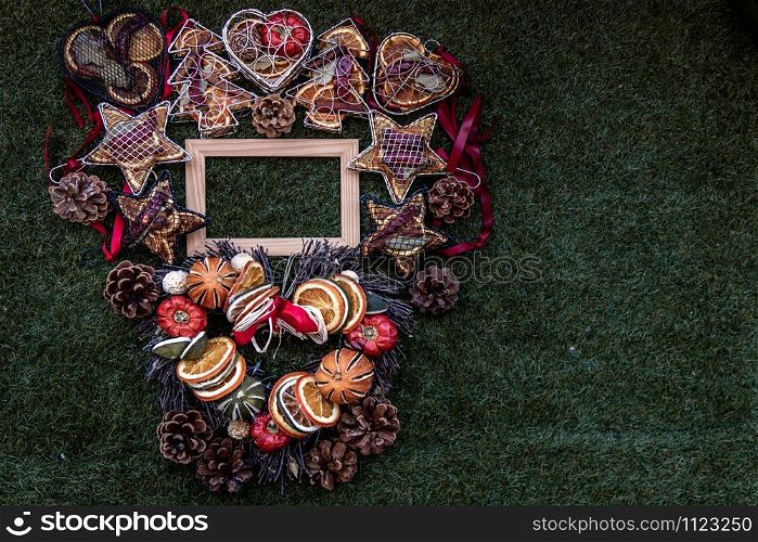 Christmas decoration, Brown natural pine cones and variety of fruits with Empty wooden frame for work about design element on lawn background, Copy Space.