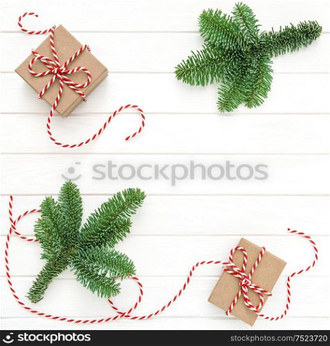 Christmas decoration. Christmas tree branches and gift boxes on bright wooden background