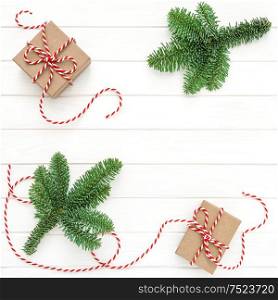 Christmas decoration. Christmas tree branches and gift boxes on bright wooden background