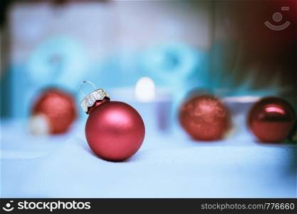 Christmas decoration: Close up of red Christmas baubles, advent calendar in the blurry background