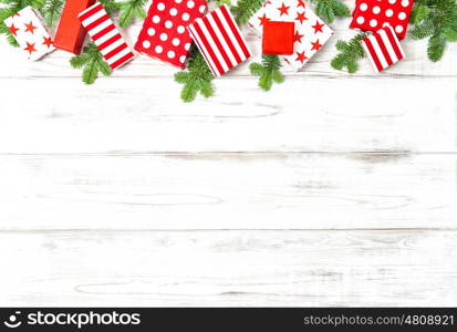 Christmas decoration, gifts and pine tree branches on bright wooden background