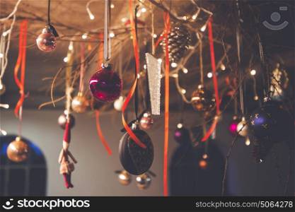 Christmas decoration hanging from a ceiling in a rural barn with xmas baubles and ribbons