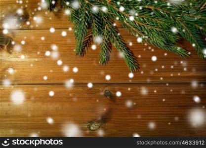 christmas, decoration, holidays and advertisement concept - close up of natural fir branch on blank brown wooden board. natural green fir branch on blank wooden board