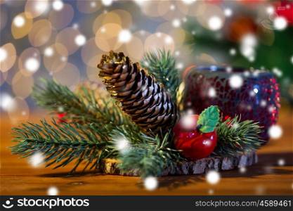 christmas, decoration, holidays and new year concept - close up of natural fir branch decoration and fir-cone and lantern on wooden table