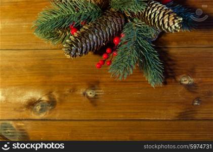 christmas decoration, holidays, new year and decor concept - close up of natural fir branch and fir-cone on wooden table