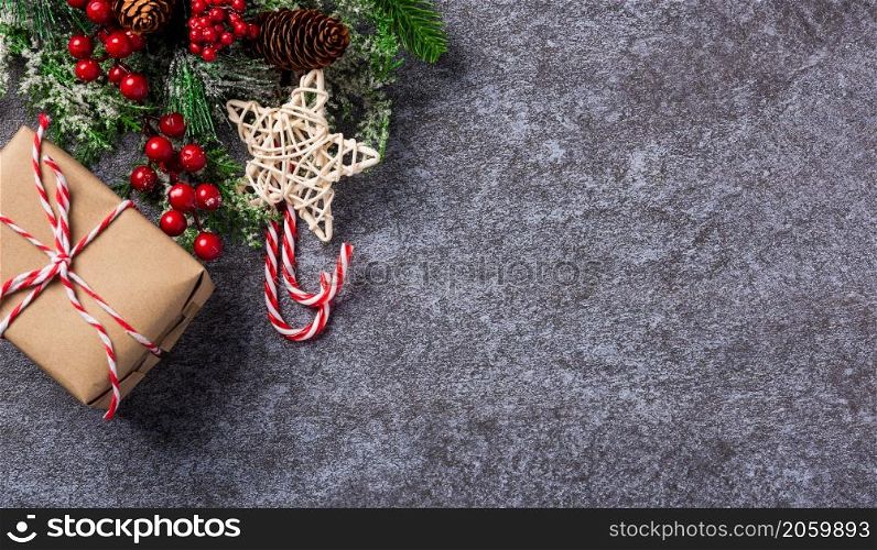 Christmas decoration holidays. Top view flat lay of border green fir tree branches with Xmas ornaments, a gift box and the star on concrete table background with copy space for text