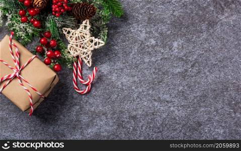 Christmas decoration holidays. Top view flat lay of border green fir tree branches with Xmas ornaments, a gift box and the star on concrete table background with copy space for text