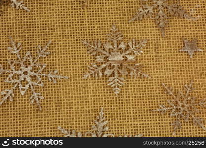 Christmas decoration, interesting background with silver stars on the floor with thick braided cord material. Flat, horizontal view from top