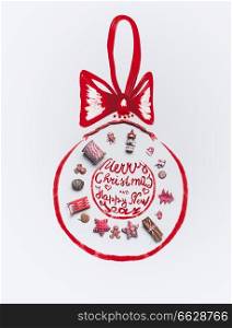 Christmas decoration objects laid out in  shape of Christmas bauble with ribbon and text lettering: Merry Christmas and  Happy New Year,  on white background, top view. Holiday greeting card