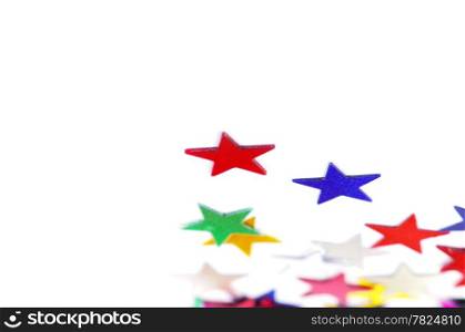 Christmas decoration of colored confetti stars against white background