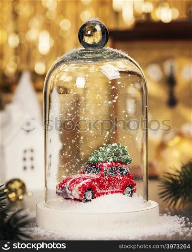 Christmas decoration on abstract gold background. Car with Christmas tree inside the Christmas snow globe.. Christmas decorations background - top view, flat lay