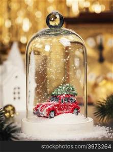 Christmas decoration on abstract gold background. Car with Christmas tree inside the Christmas snow globe.. Christmas decorations background - top view, flat lay
